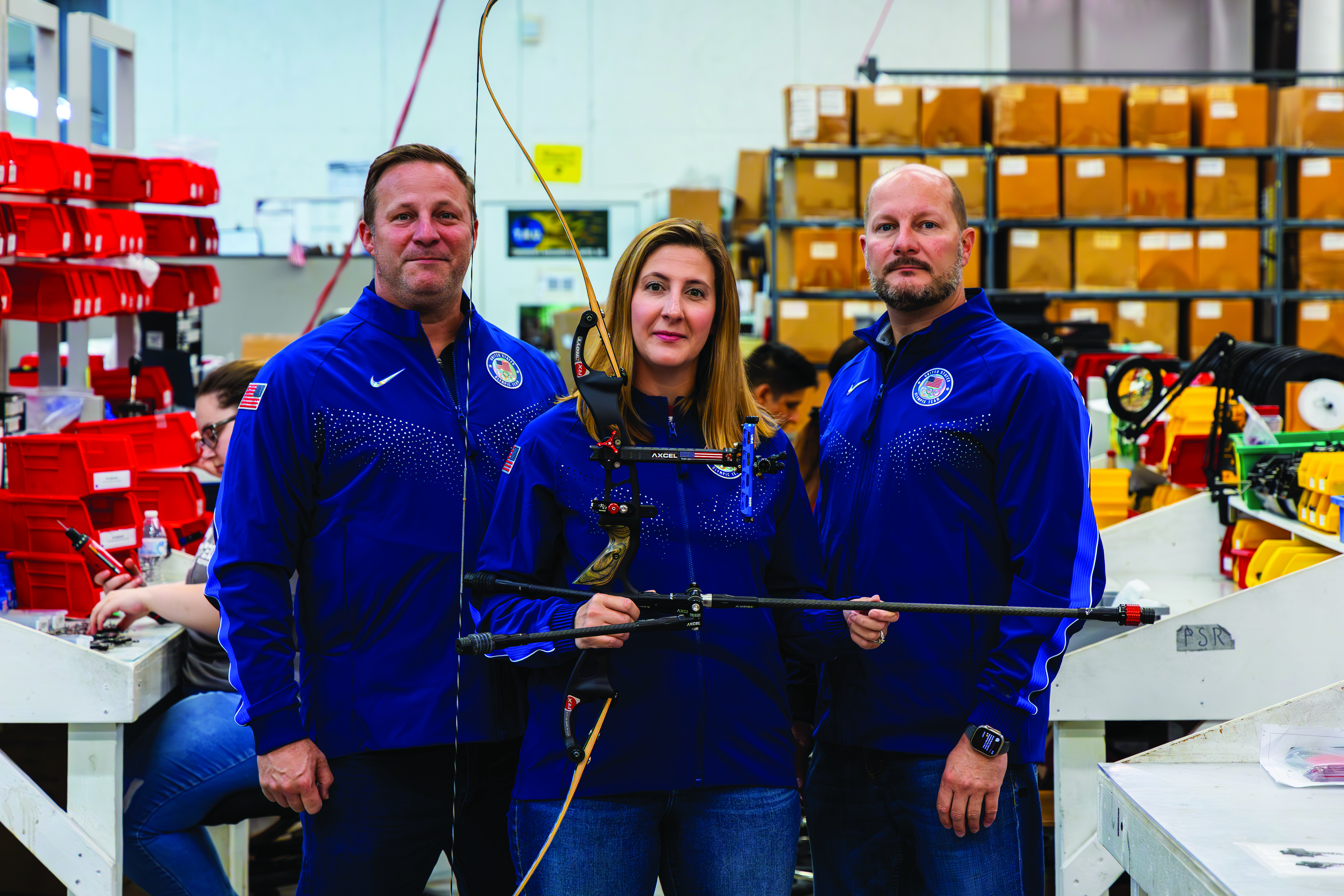 A photo of 3 T.R.U. Ball Archery employees in Amherst County holding a bow and arrow. 